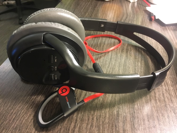 99 Cent Store Bluetooth Wireless Headphones, sitting on top of Beats by Dre PowerBeats2 wireless earbuds